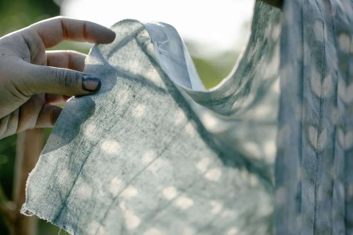 Indigo-dyed cotton showing intricate white shibori patterns of rings and creases