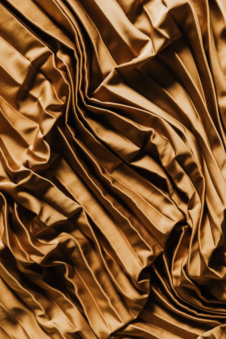Artisan threading multicolored silk yarns through a traditional jacquard loom in a Kyoto Nishijin weaving workshop.