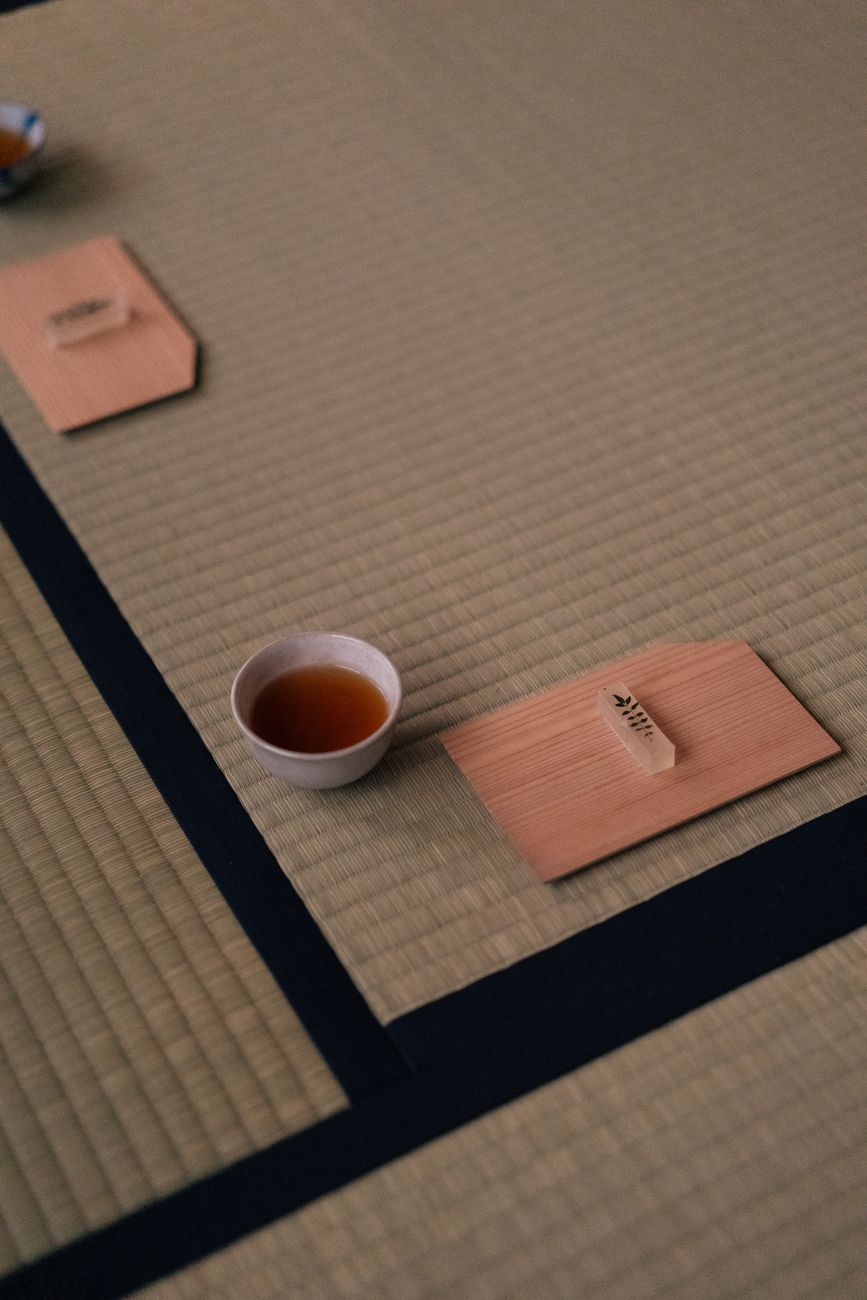 Craftsman weaving soft rush igusa straw into tight rows on a traditional wooden loom for tatami mat construction.