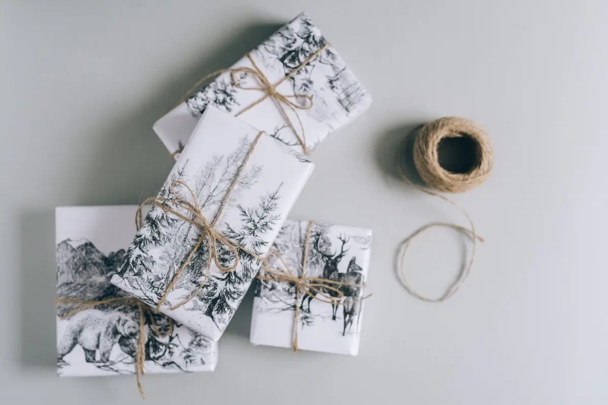 Colorful decorative envelopes with traditional Japanese patterns containing crisp bills, arranged beside pine and plum blossom New Year decorations.