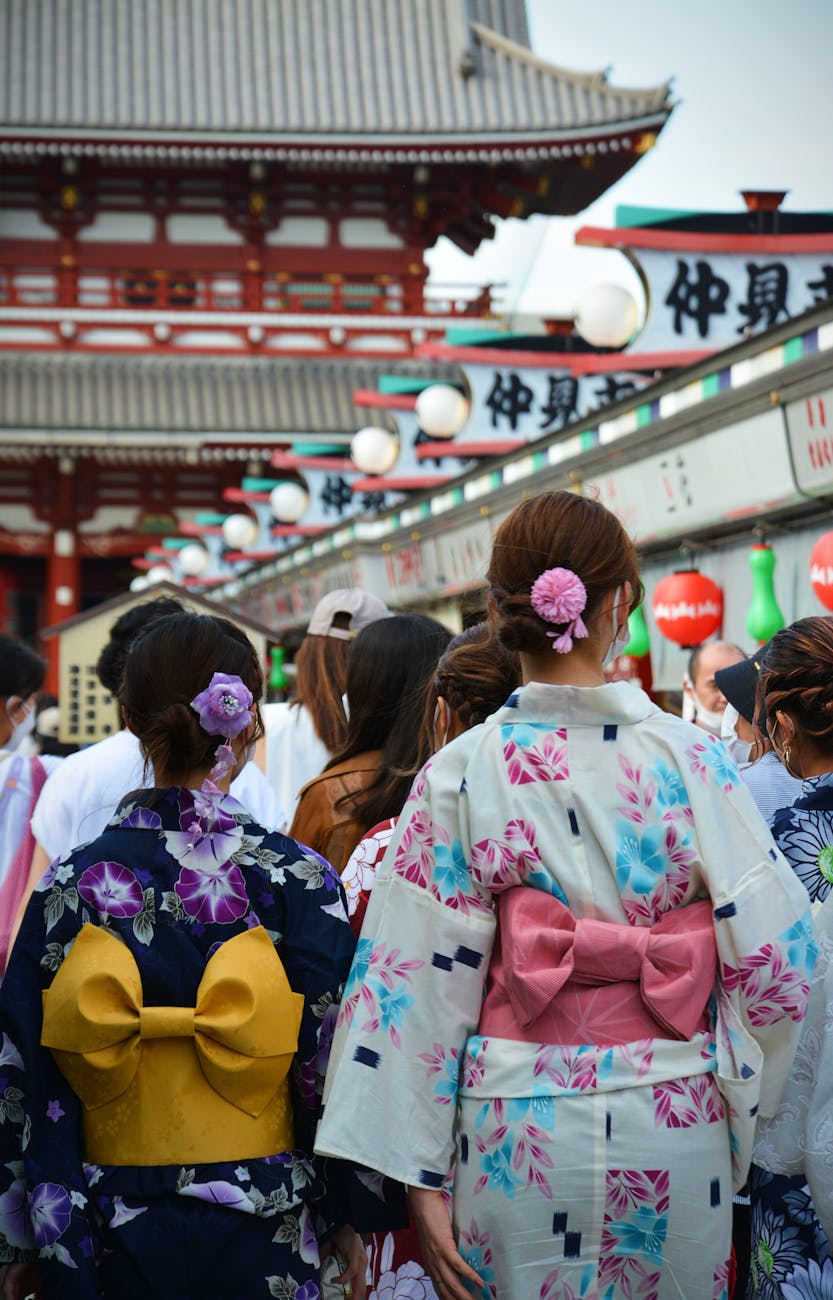 Two Japanese businesspeople in formal attire bowing to each other at different angles on a city street in Tokyo.
