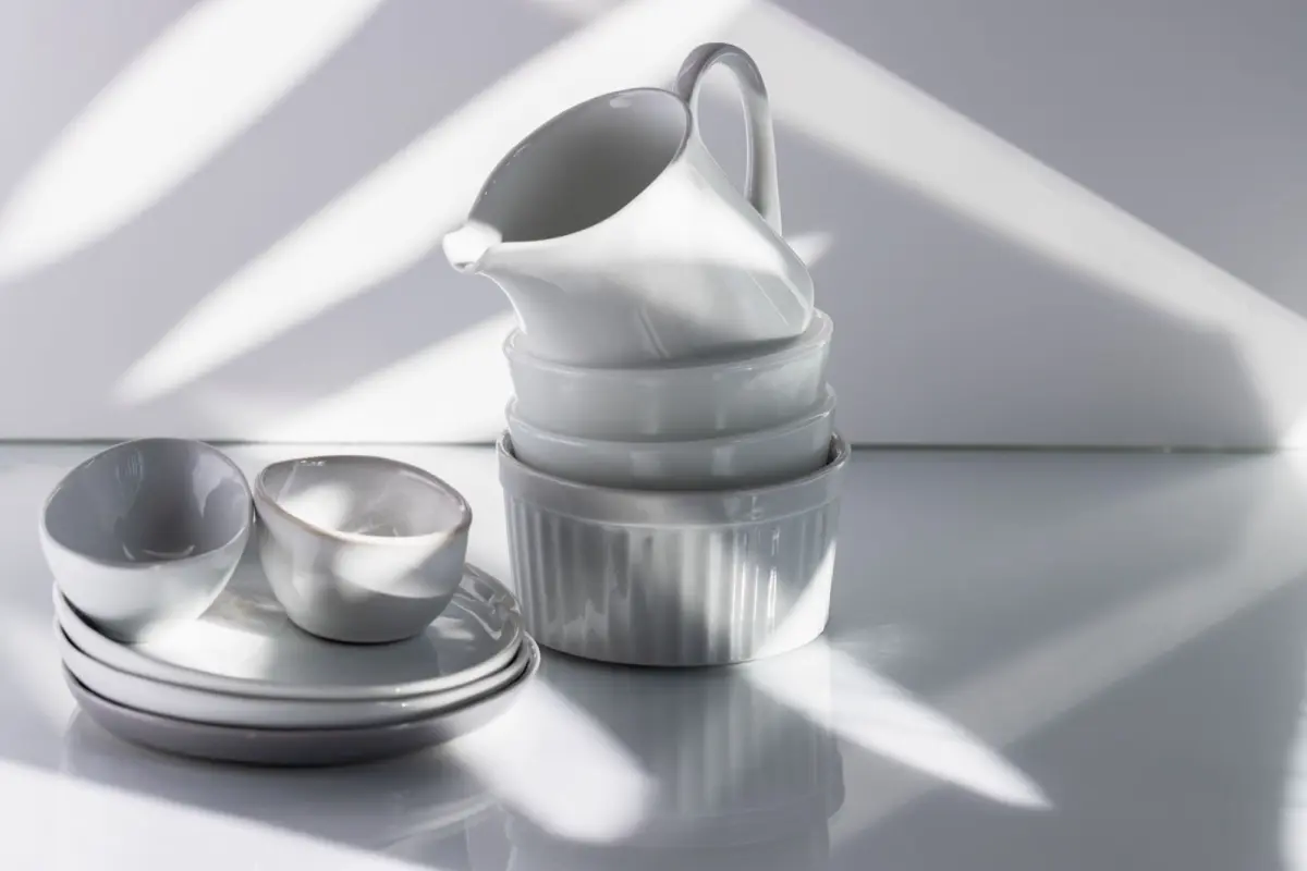 White and blue porcelain bowls and plates with minimalist designs stacked together, showcasing traditional Hasami ware pottery from Nagasaki, Japan.
