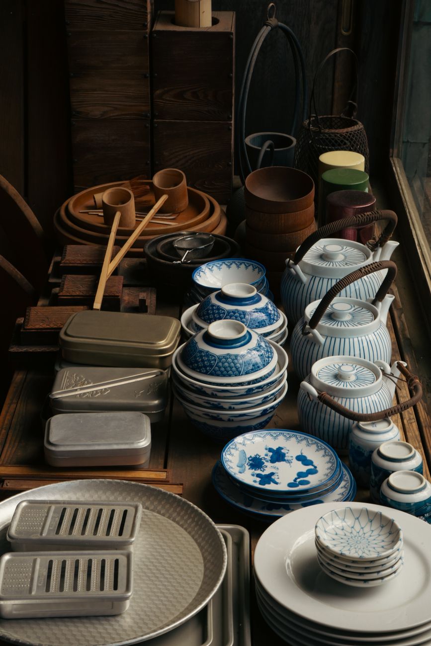 White and blue porcelain bowls and plates with minimalist designs stacked together, showcasing traditional Hasami ware pottery from Nagasaki, Japan.
