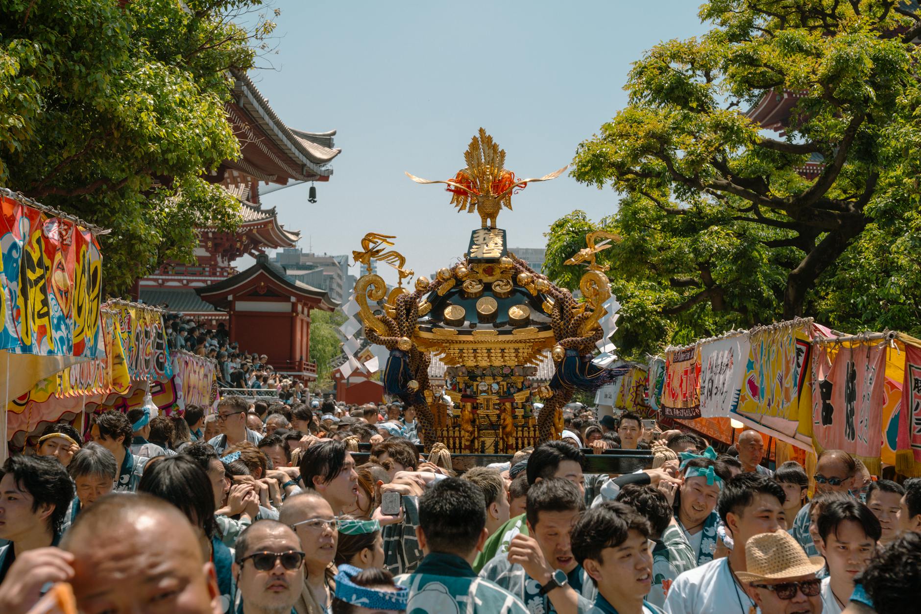 Ornate festival float adorned with lanterns and tapestries being pulled through crowded Kyoto streets during the Gion Matsuri parade.