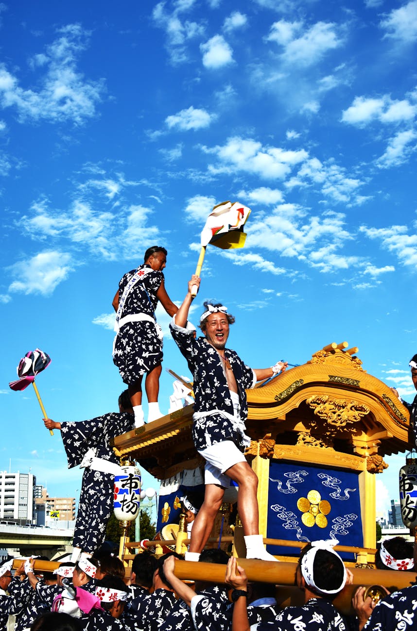 Ornate festival float adorned with lanterns and tapestries being pulled through crowded Kyoto streets during the Gion Matsuri parade.