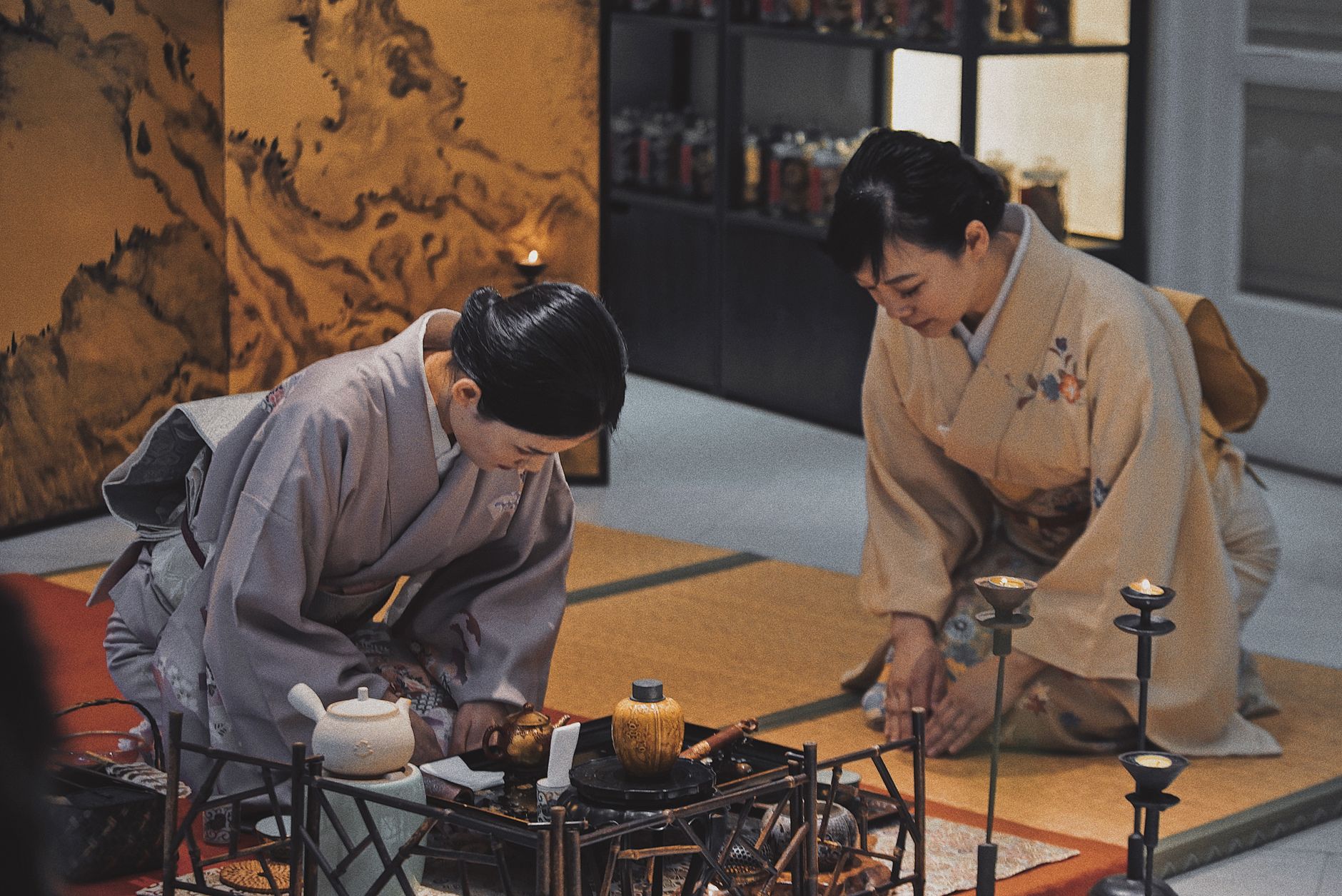 A tea practitioner whisking matcha in a ceramic bowl during a traditional Japanese tea ceremony in a quiet tatami room.