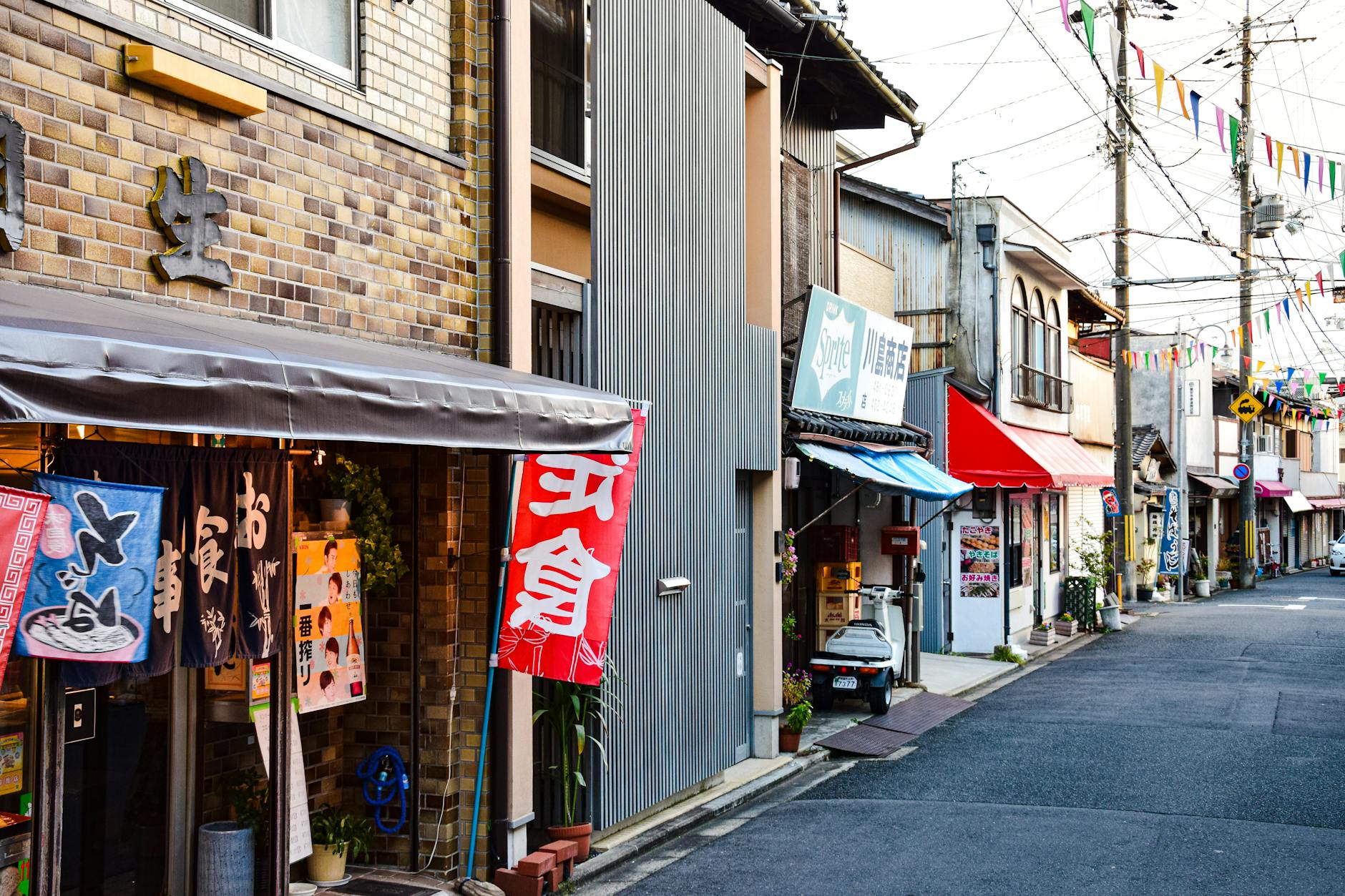 Traditional wooden machiya townhouse facade in Kyoto with latticed windows, dark timber beams, and narrow street frontage showcasing Edo-period architecture.