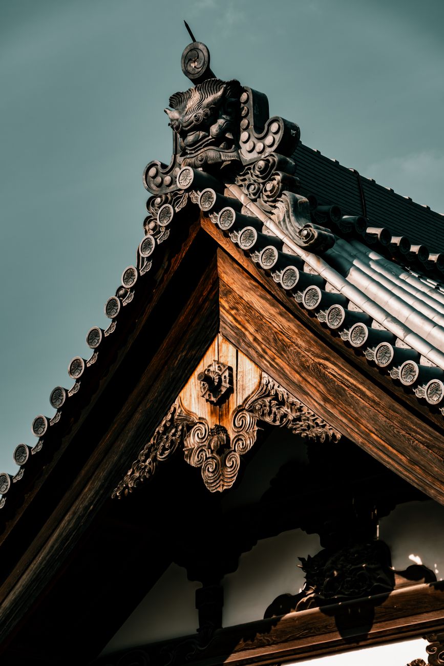 Traditional wooden machiya townhouse facade in Kyoto with latticed windows, dark timber beams, and narrow street frontage showcasing Edo-period architecture.