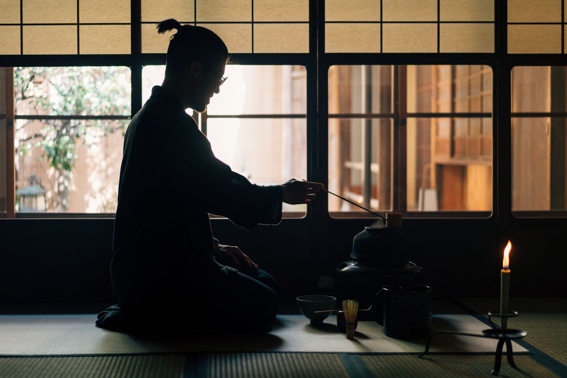 Rustic tea house interior with weathered wooden beams, earthen walls, and soft natural light filtering through shoji screens.