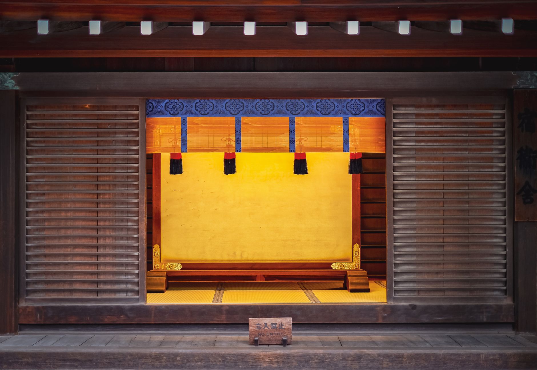 Traditional Japanese room with six tatami mats arranged in geometric pattern, shoji screens along walls, and low wooden table in center.