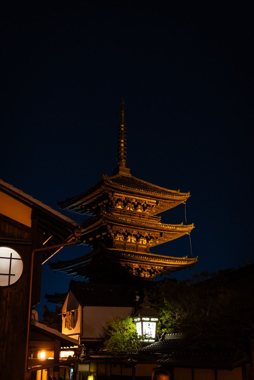 Traditional Kyoto machiya townhouse showing distinctive narrow street-facing facade with wooden lattice windows and deep interior extending backward.