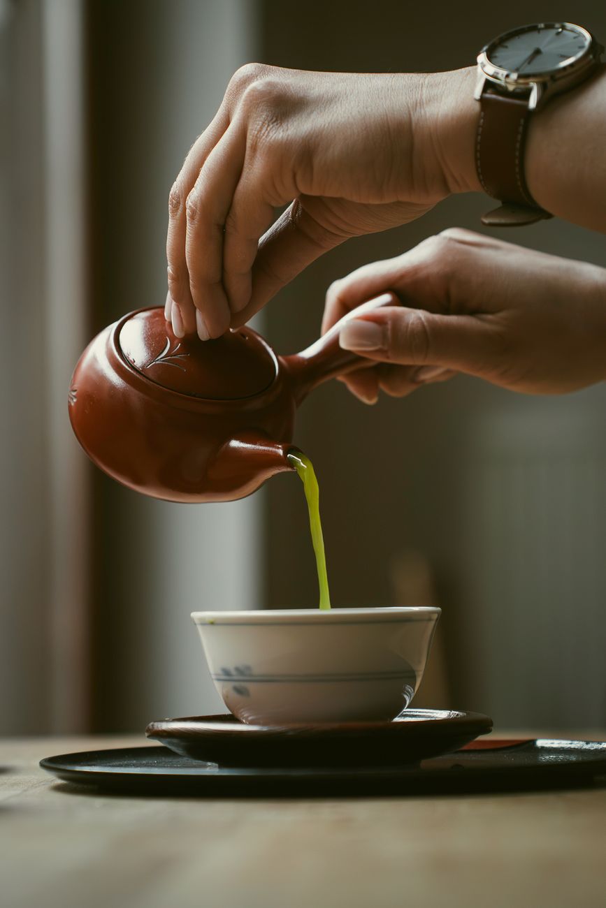 Bright green matcha powder in ceramic bowls showing color variations from ceremonial grade to culinary grade side by side.