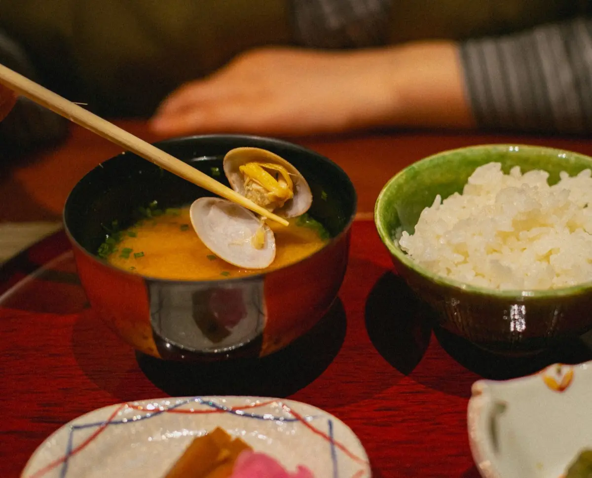 Kombu kelp and katsuobushi bonito flakes beside a pot of clear Japanese dashi stock