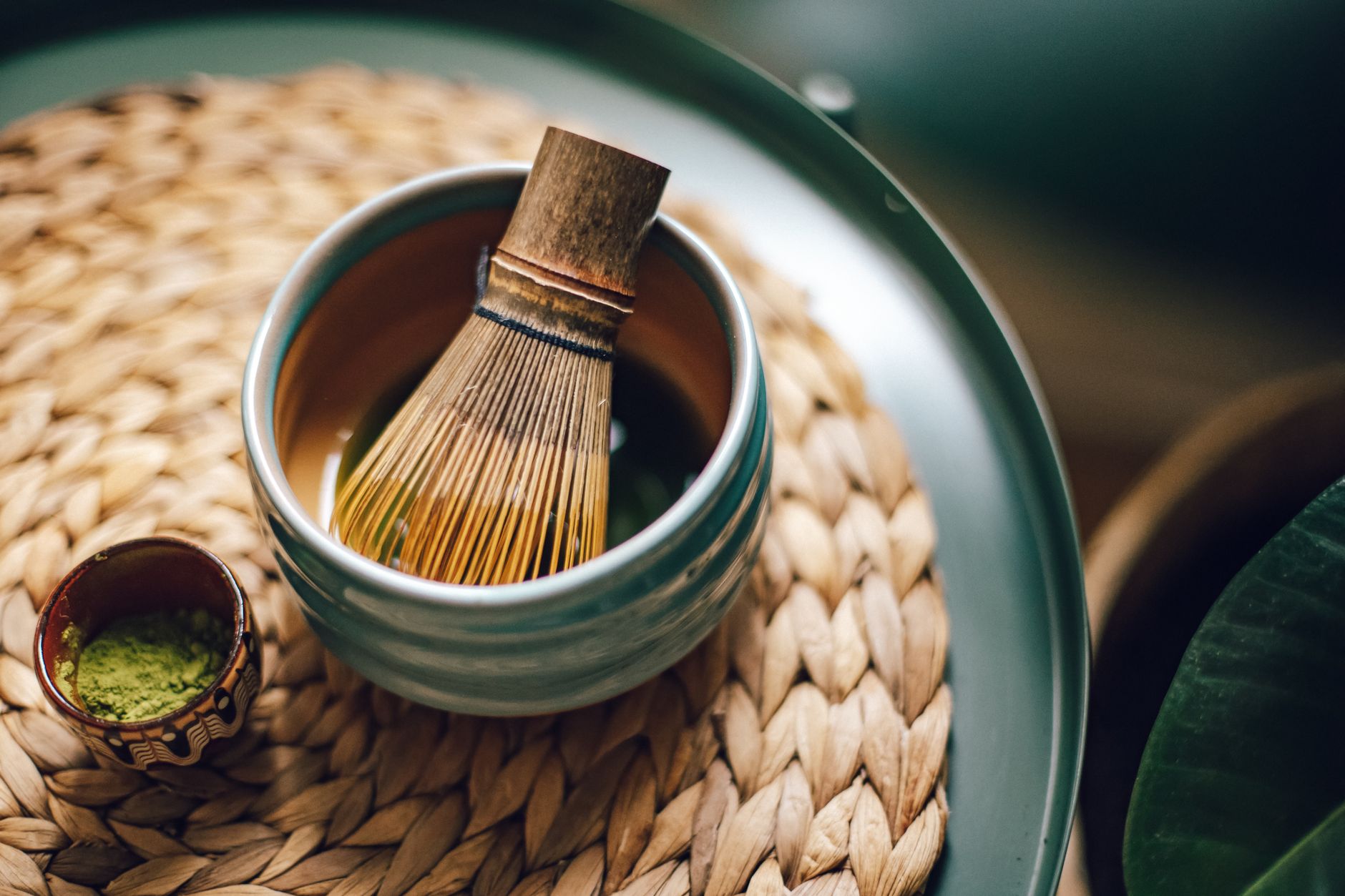 Bowl of thick koicha matcha beside thin usucha matcha showing contrast in consistency and foam texture during Japanese tea ceremony.