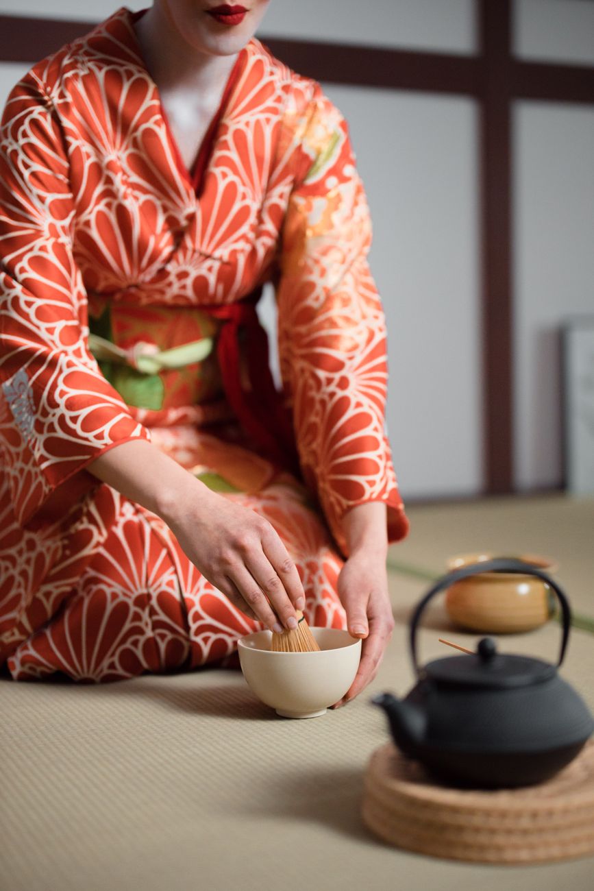 Thick koicha matcha in a ceramic tea bowl showing dense, paste-like consistency with bamboo whisk resting beside it.