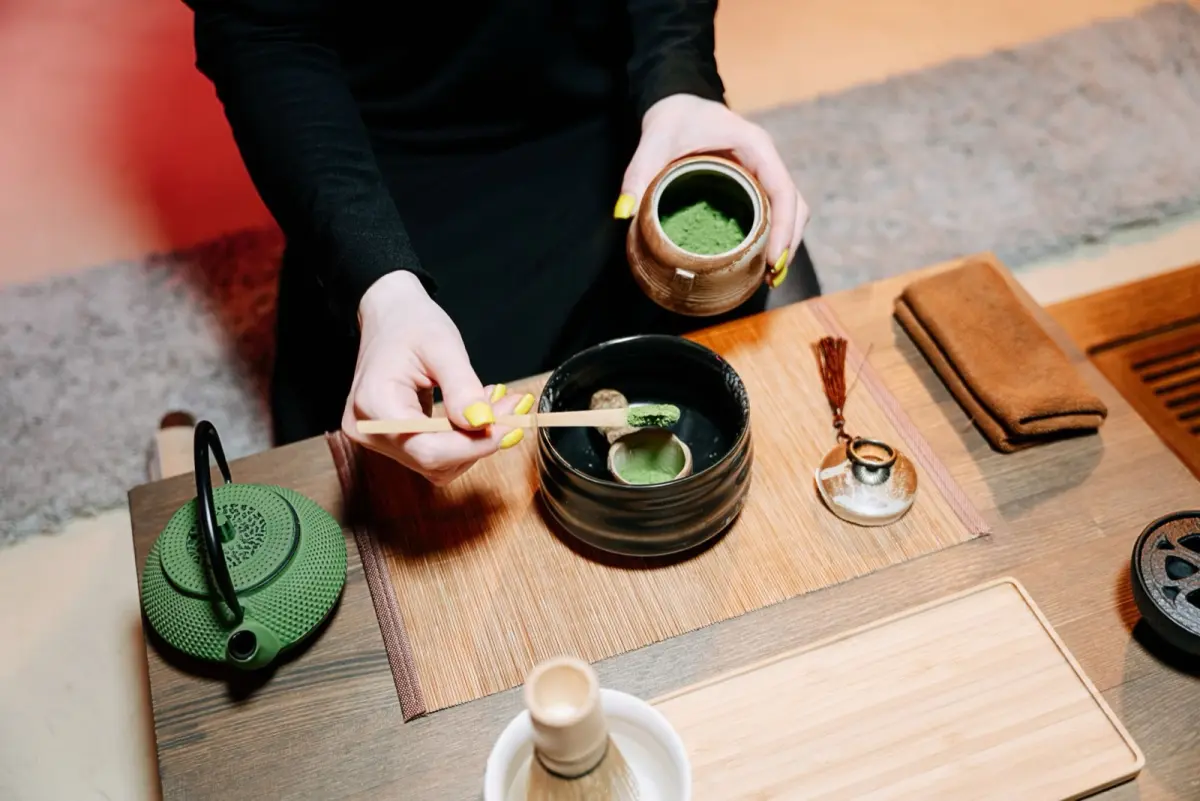Vibrant green matcha powder in a ceramic bowl beside duller oxidized matcha showing quality differences through color comparison.