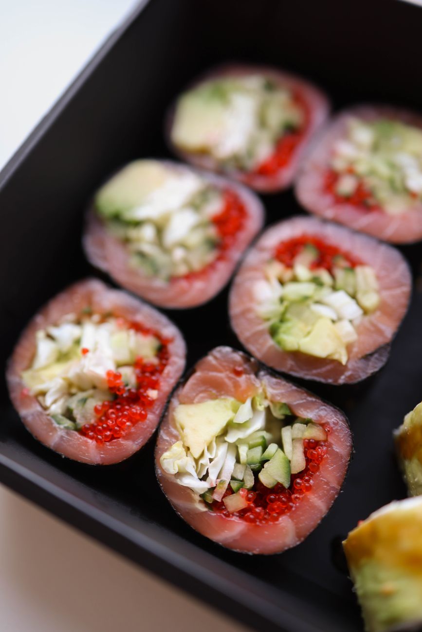 Fresh nigiri sushi arranged on hinoki cypress board showing tuna, sea bream, and kohada with wasabi in traditional Edomae style.