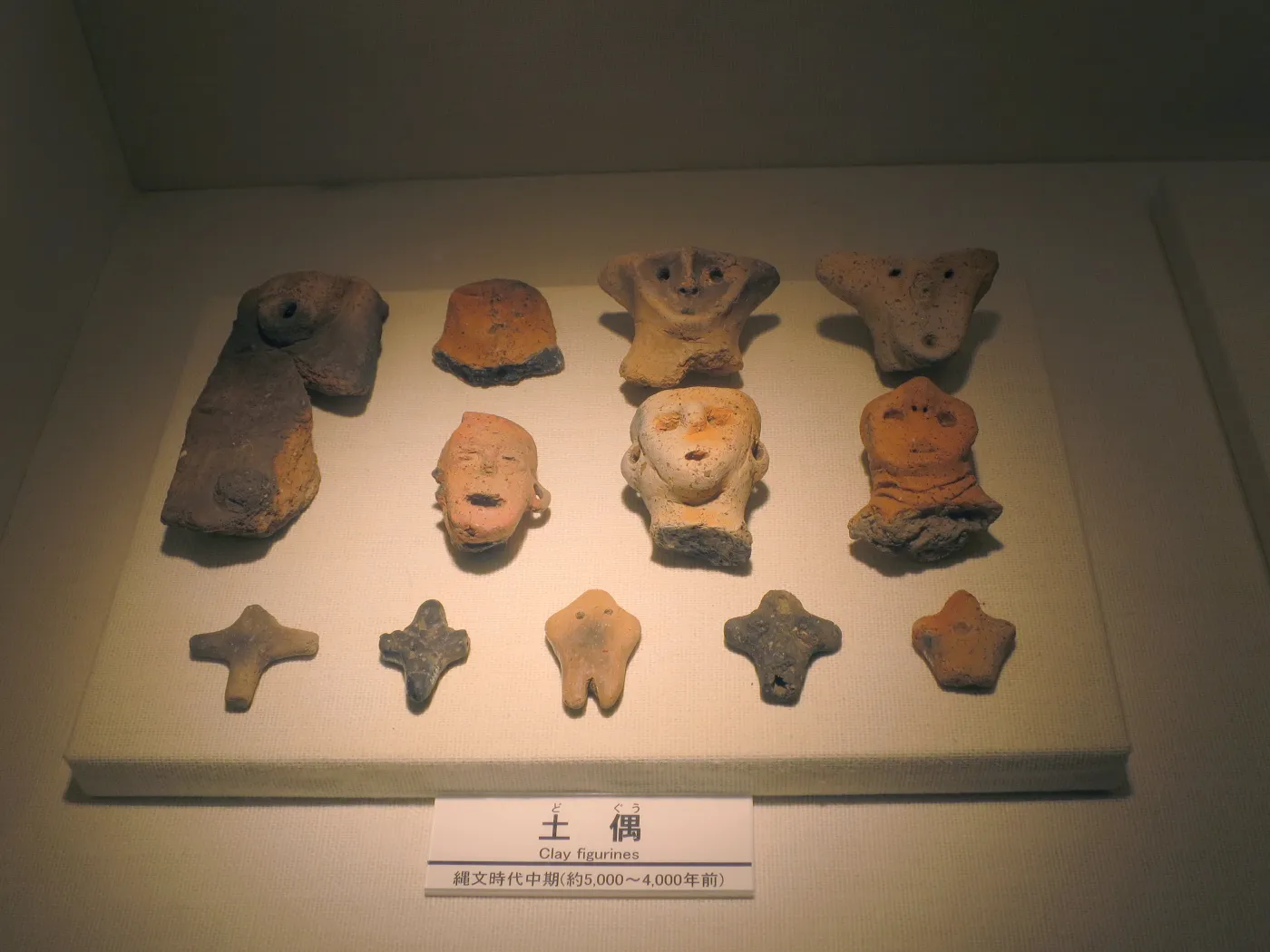 Ancient Jomon pottery vessel with distinctive cord-marked patterns and flame-like rim decorations from prehistoric Japan.