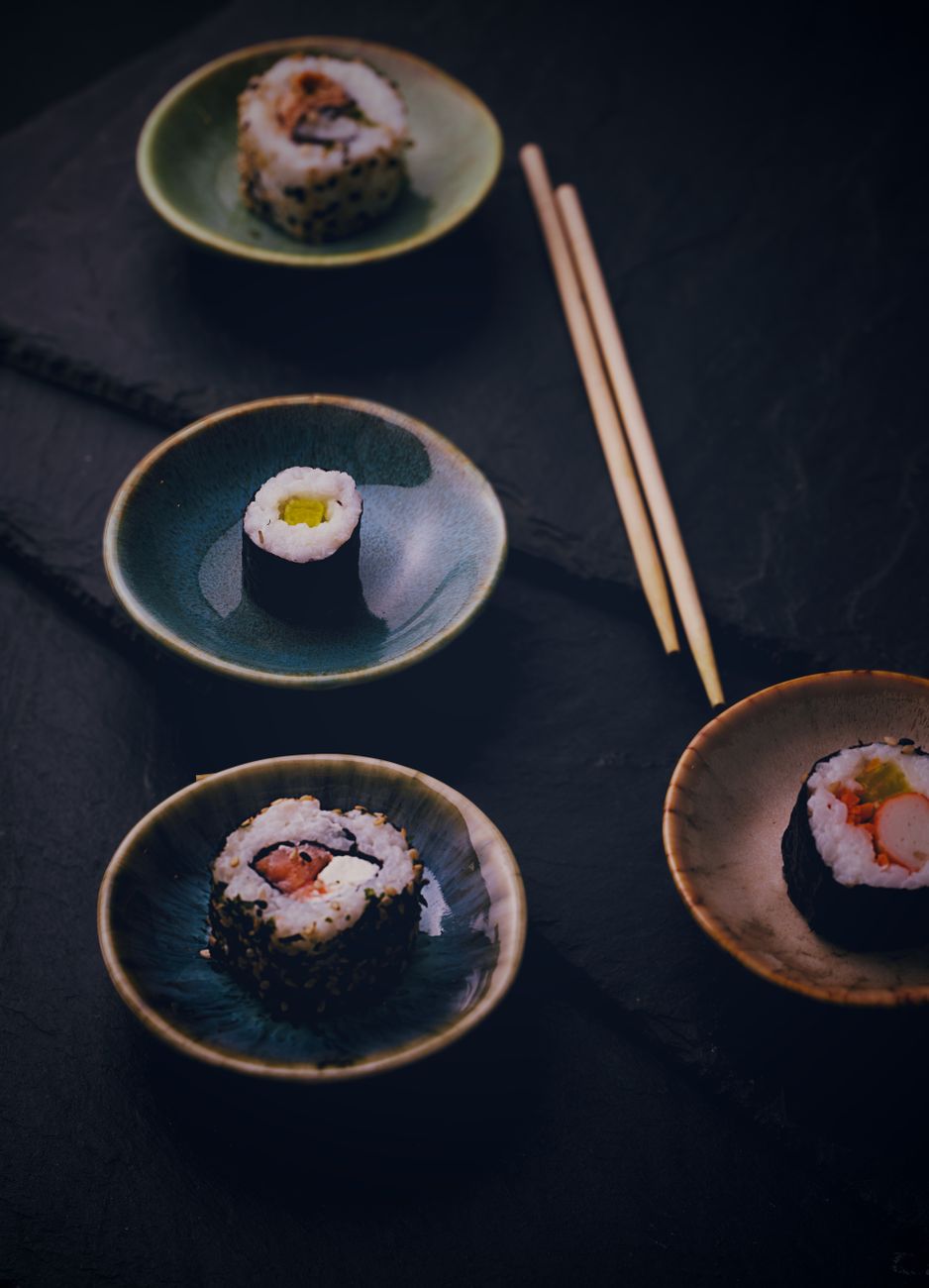 Edo-period wooden chopsticks rest on lacquered tray beside ceramic bowl in traditional Japanese dining arrangement.
