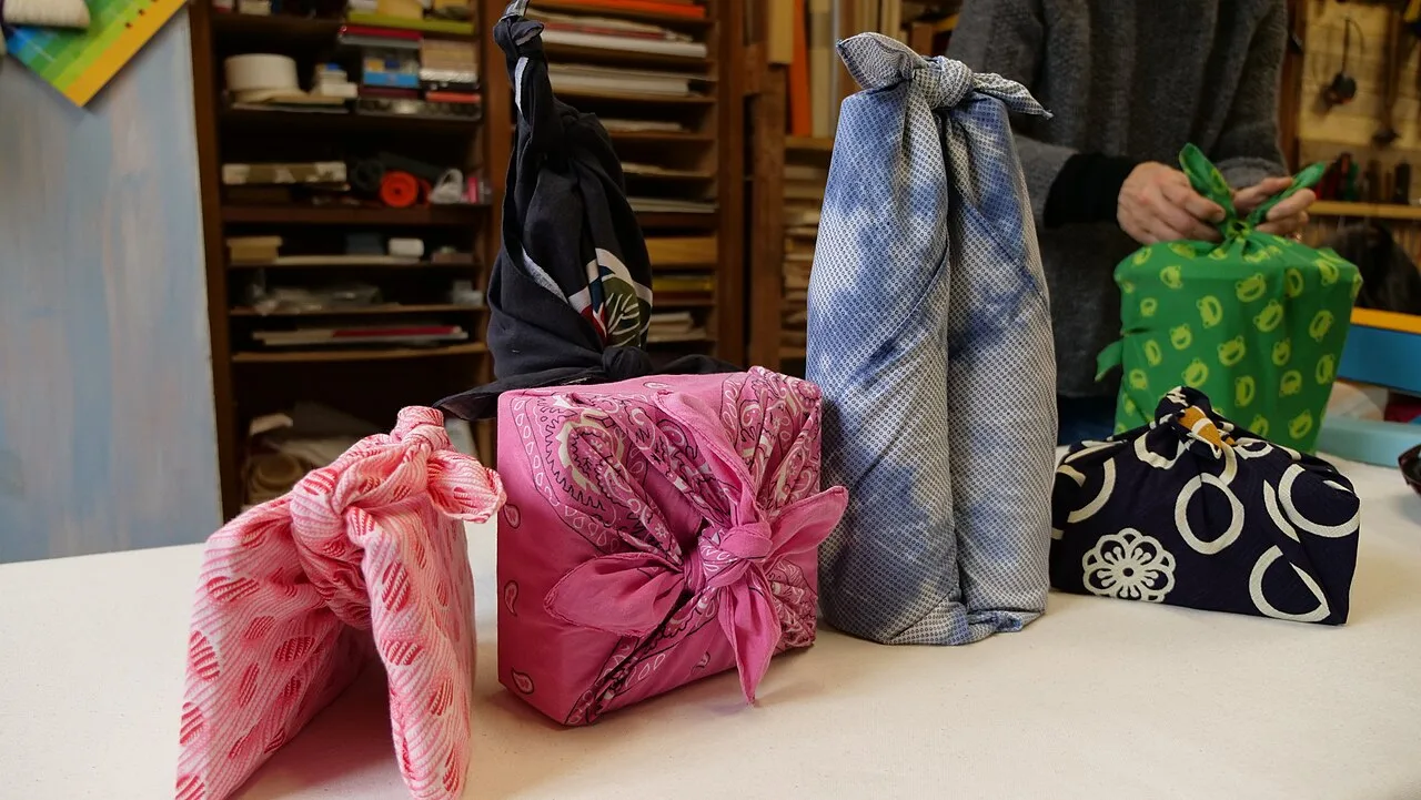 A gift wrapped in a patterned furoshiki cloth tied with a neat knot on top