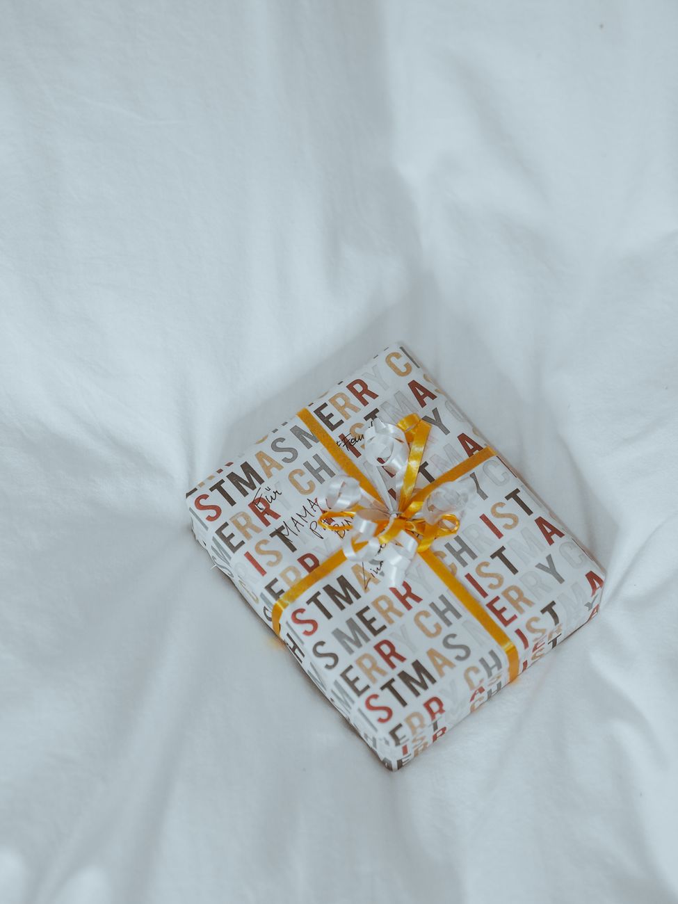 Traditional Japanese furoshiki cloth wrapping a gift box using diagonal fold technique with floral pattern fabric and knotted corners.