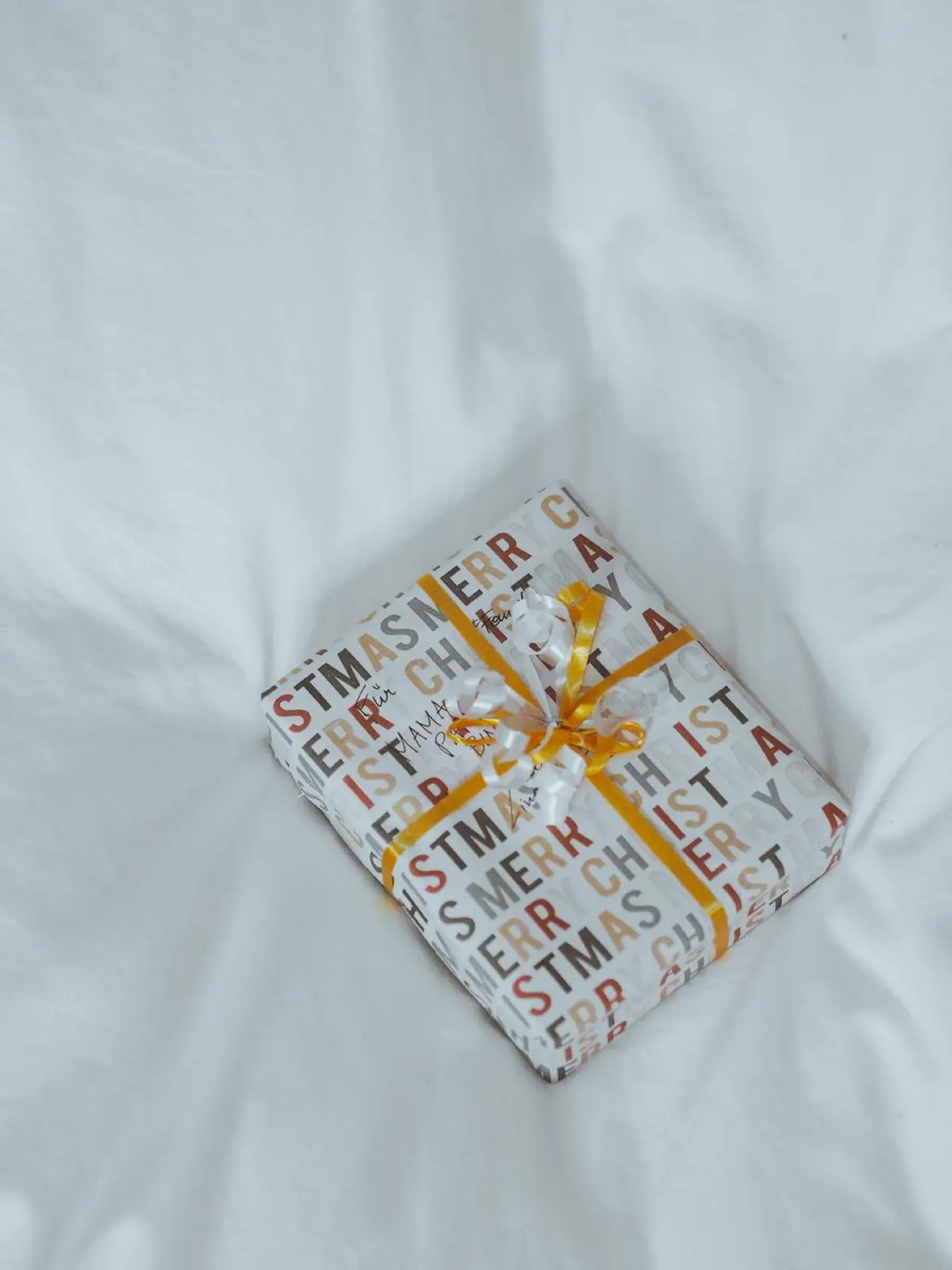 A gift wrapped in a patterned furoshiki cloth tied with a neat knot on top