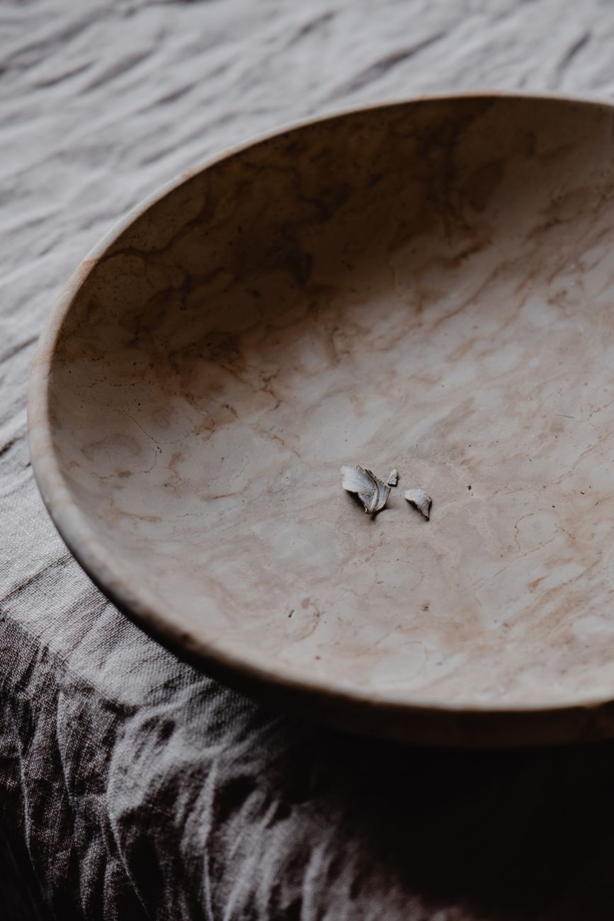 A cracked ceramic bowl repaired with gold lacquer, showing golden seams that highlight the break lines rather than hide them.