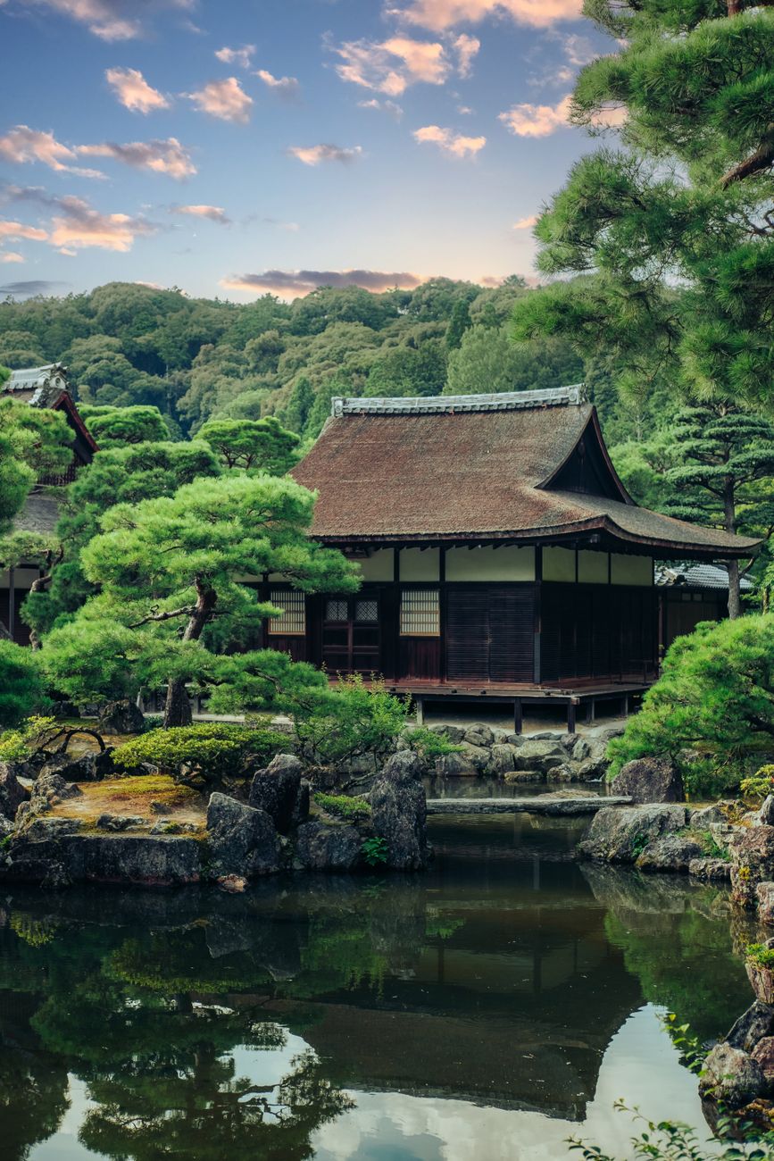 Fifteen weathered stones arranged in carefully raked white gravel at Ryoanji Temple's minimalist Zen rock garden in Kyoto.