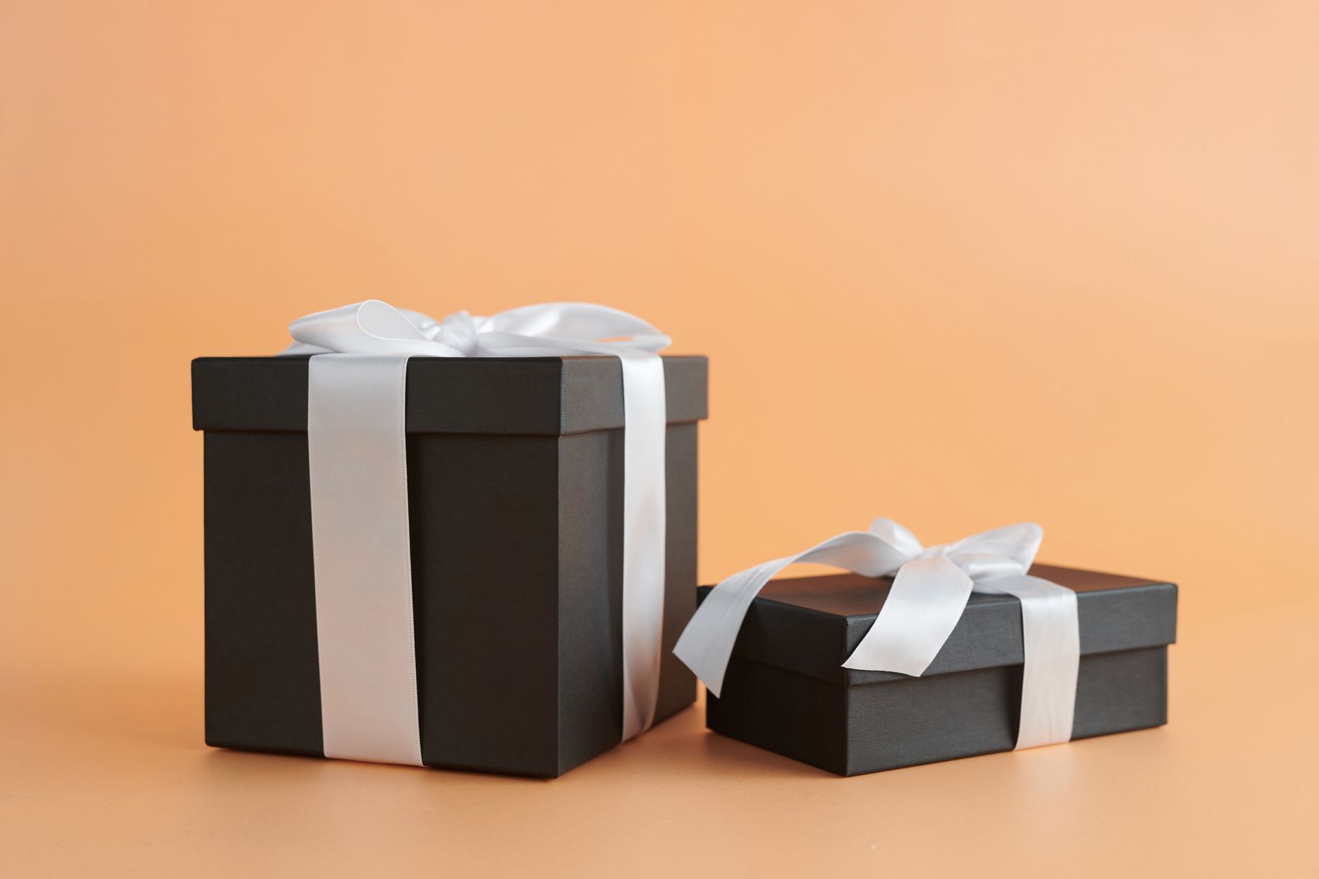 Wrapped gift boxes with traditional mizuhiki cord decorations arranged on a wooden table for Japanese seasonal gift-giving ceremony.