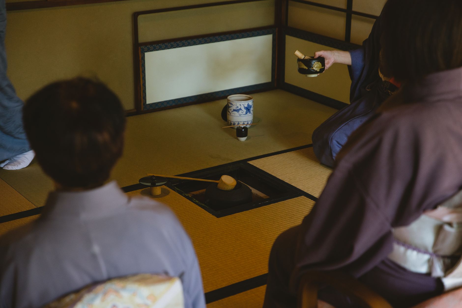 Two Japanese colleagues bowing respectfully to each other in a modern office hallway, demonstrating workplace social harmony.
