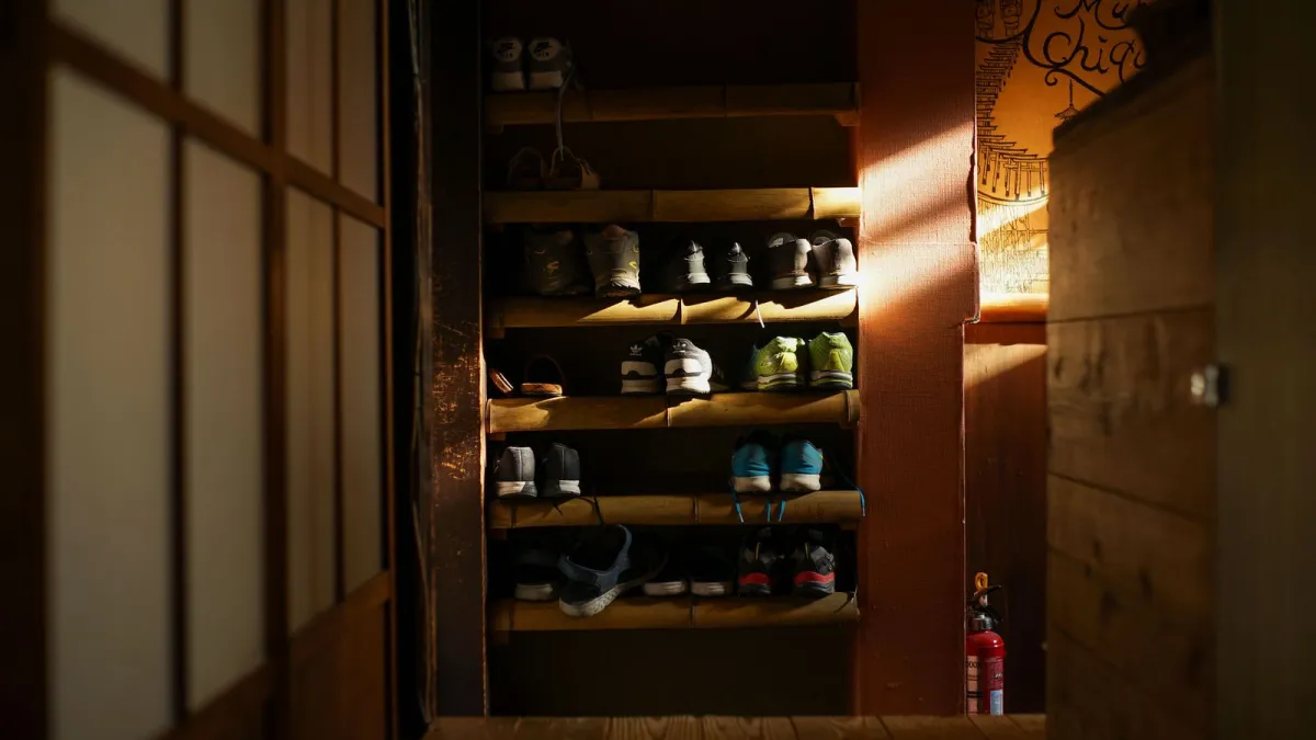 Shoes neatly removed and arranged in a Japanese genkan entrance, with slippers waiting on the step