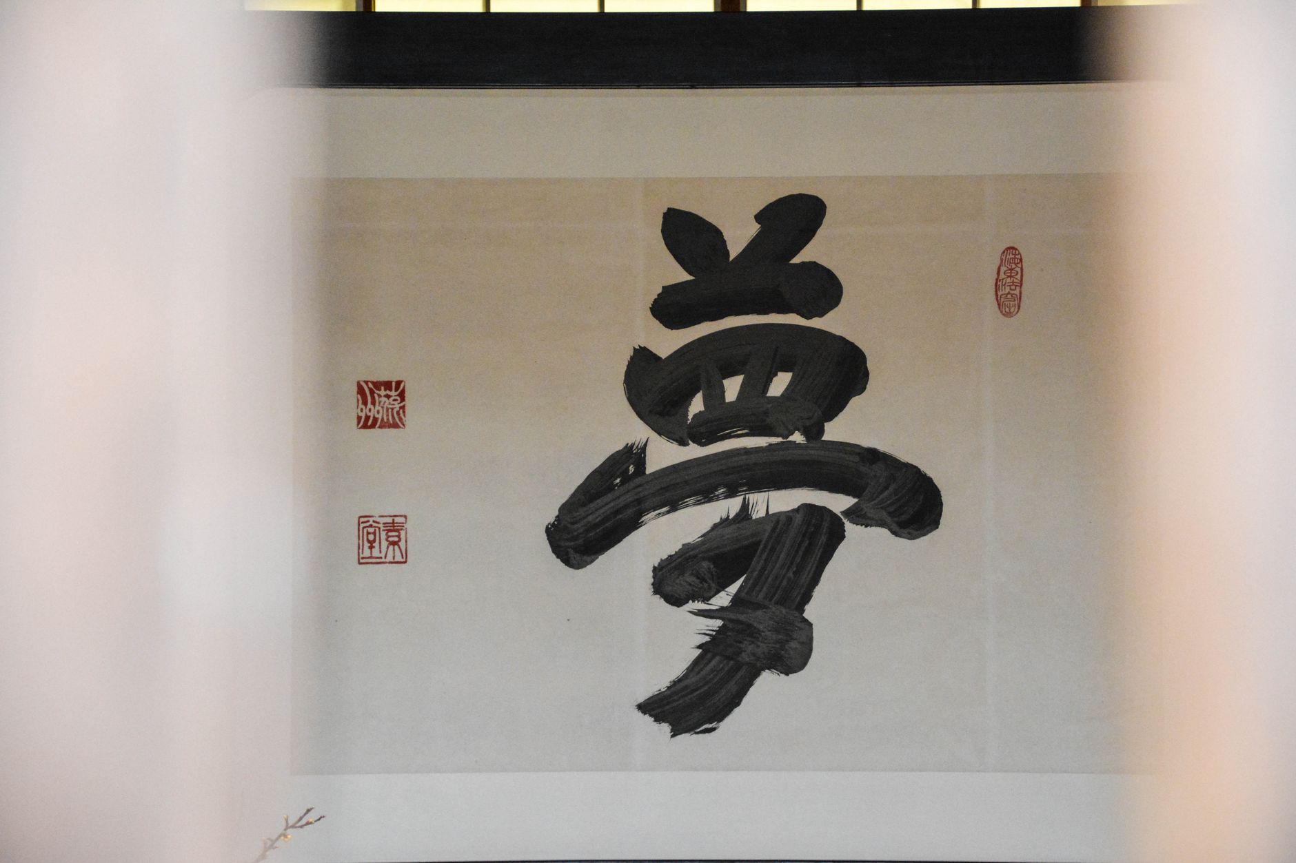 Black ink brush strokes forming bamboo stalks on white rice paper with traditional brush and ink stone nearby.