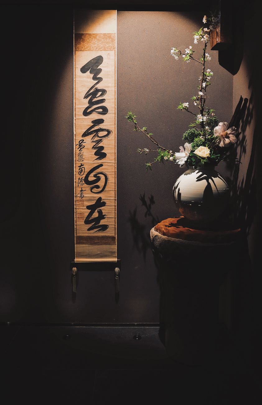 Black ink brush strokes forming bamboo stalks on white rice paper with traditional brush and ink stone nearby.