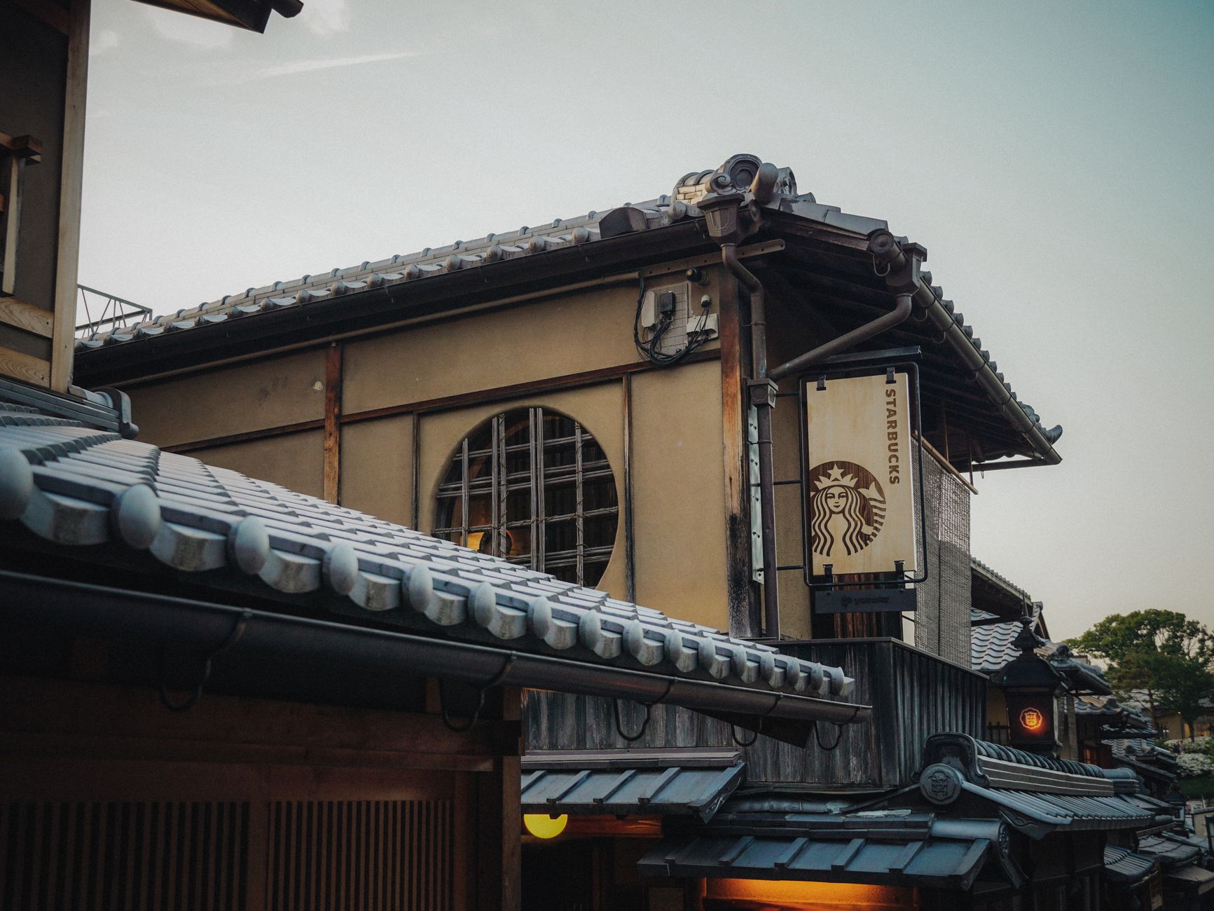 Traditional wooden tea house with sliding paper doors and tatami mat flooring in a serene Kyoto garden setting.
