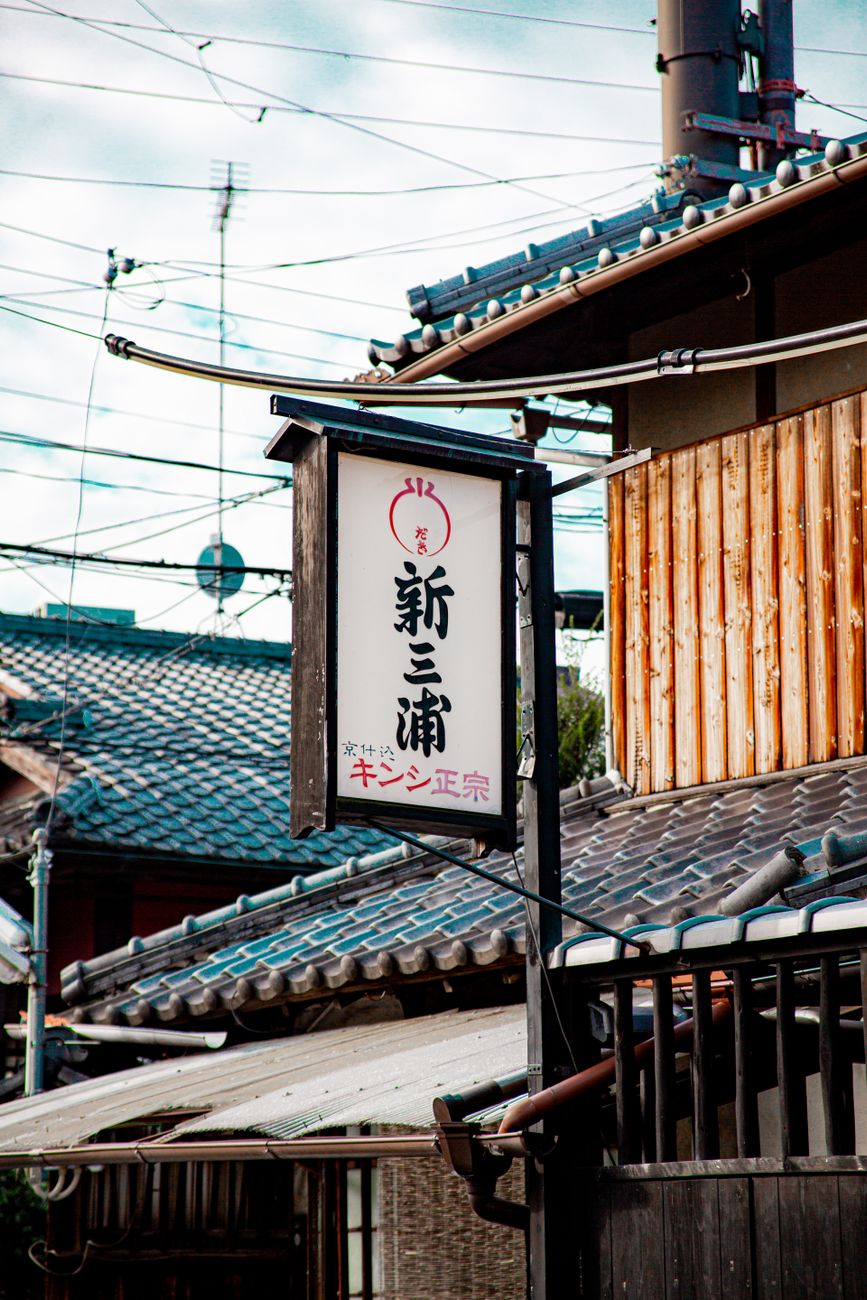 Historic Arita town street lined with traditional porcelain workshops and kilns nestled among forested hills in Saga Prefecture, Japan.