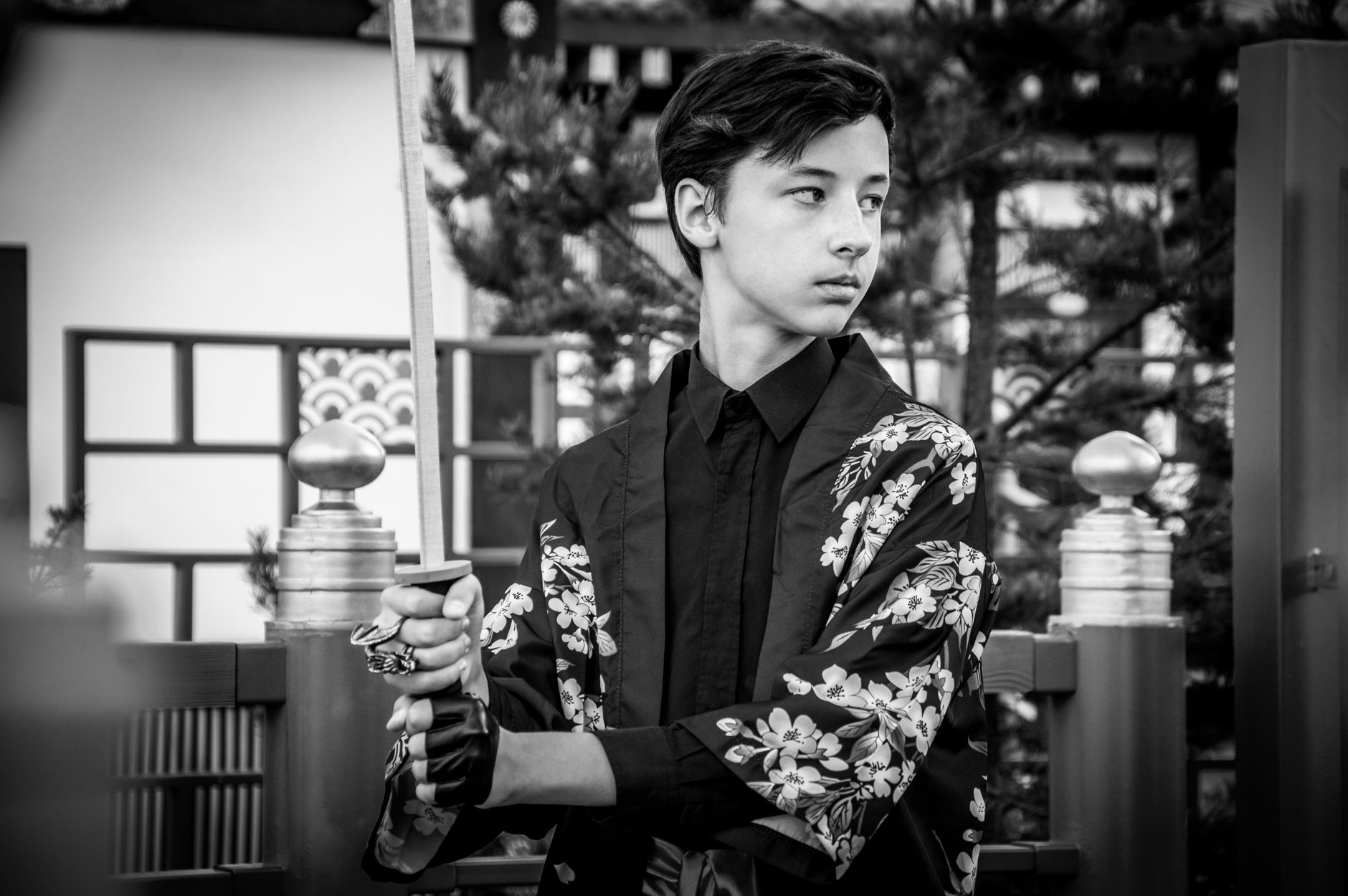 Samurai warrior in traditional armor kneeling in meditation pose inside a wooden dojo with natural light filtering through.