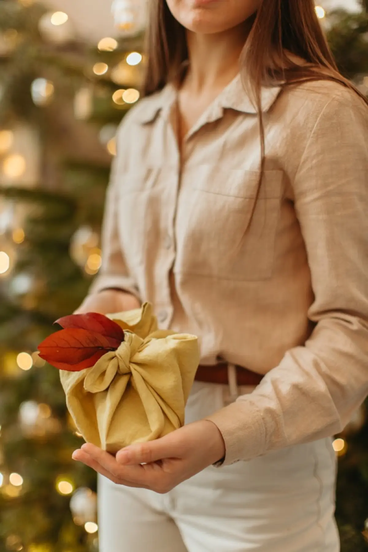 Two hands presenting a beautifully wrapped Japanese gift with both hands and a slight bow