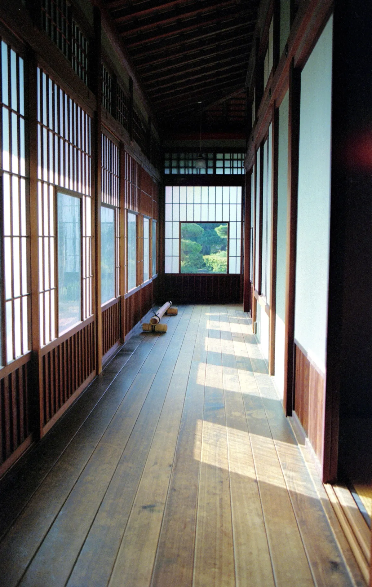 A wooden engawa veranda running along a traditional Japanese house, facing a garden