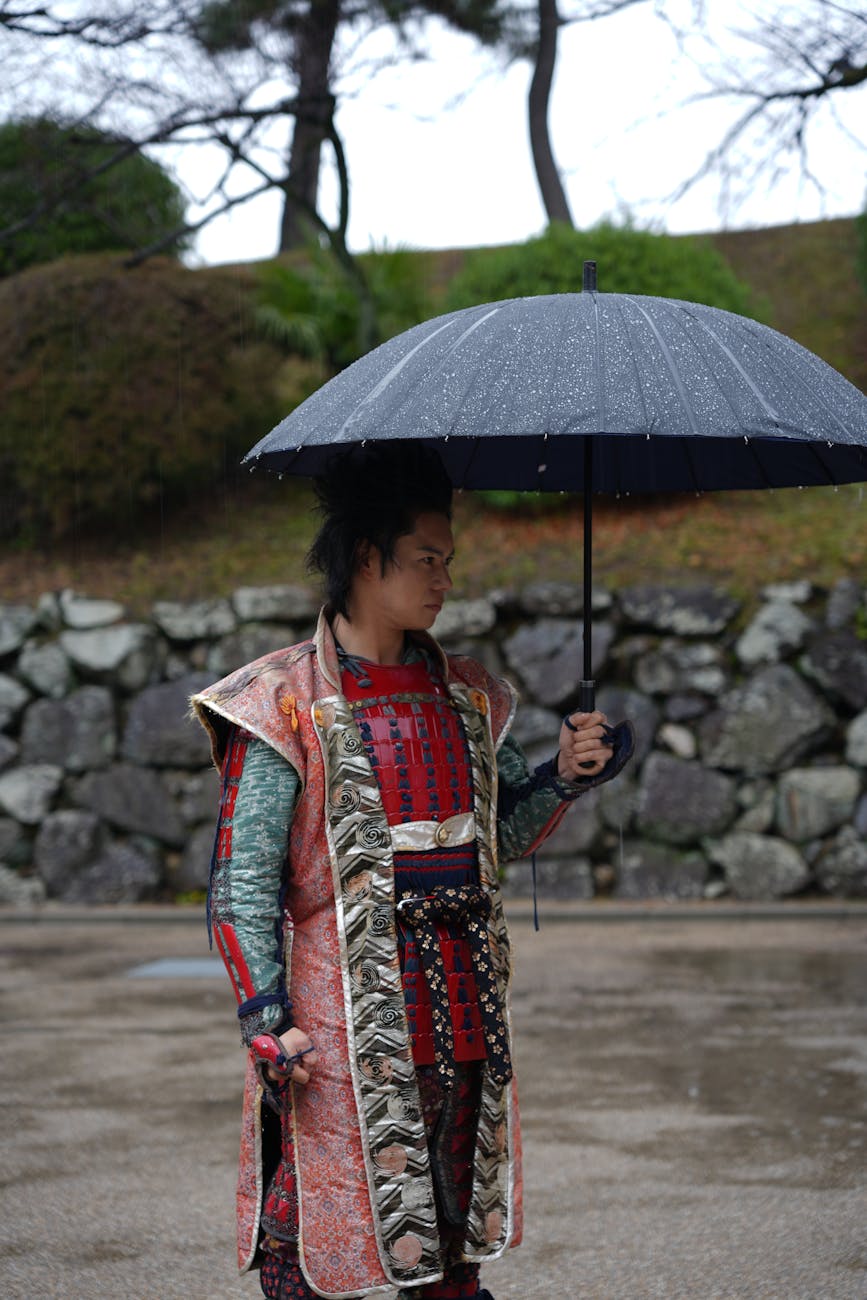 Samurai warrior in traditional armor standing in a wooden dojo, katana at his side, embodying feudal Japan's warrior class.