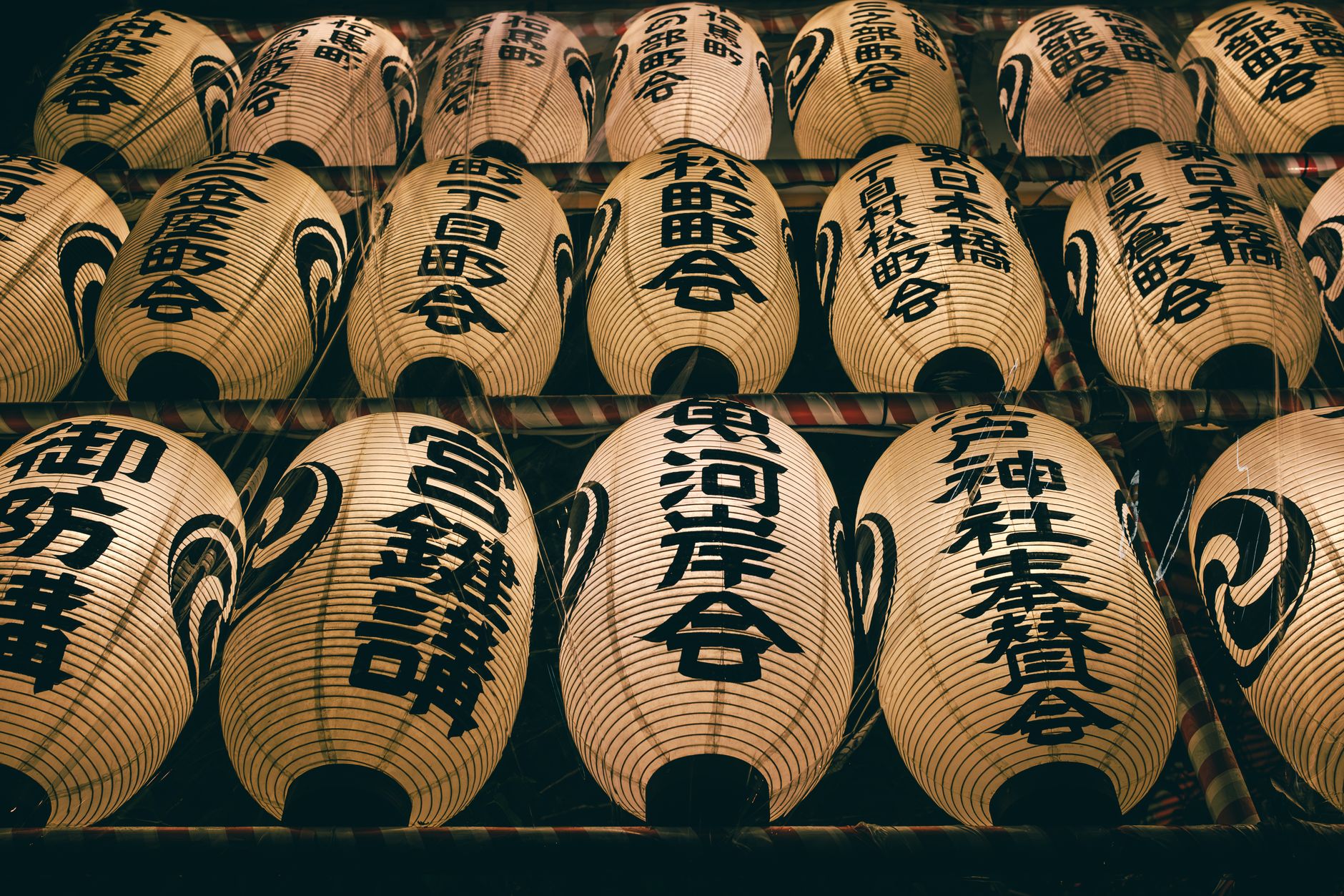 Families gather at a Buddhist altar decorated with lanterns, incense, and offerings of fruit during Obon celebrations in Japan.