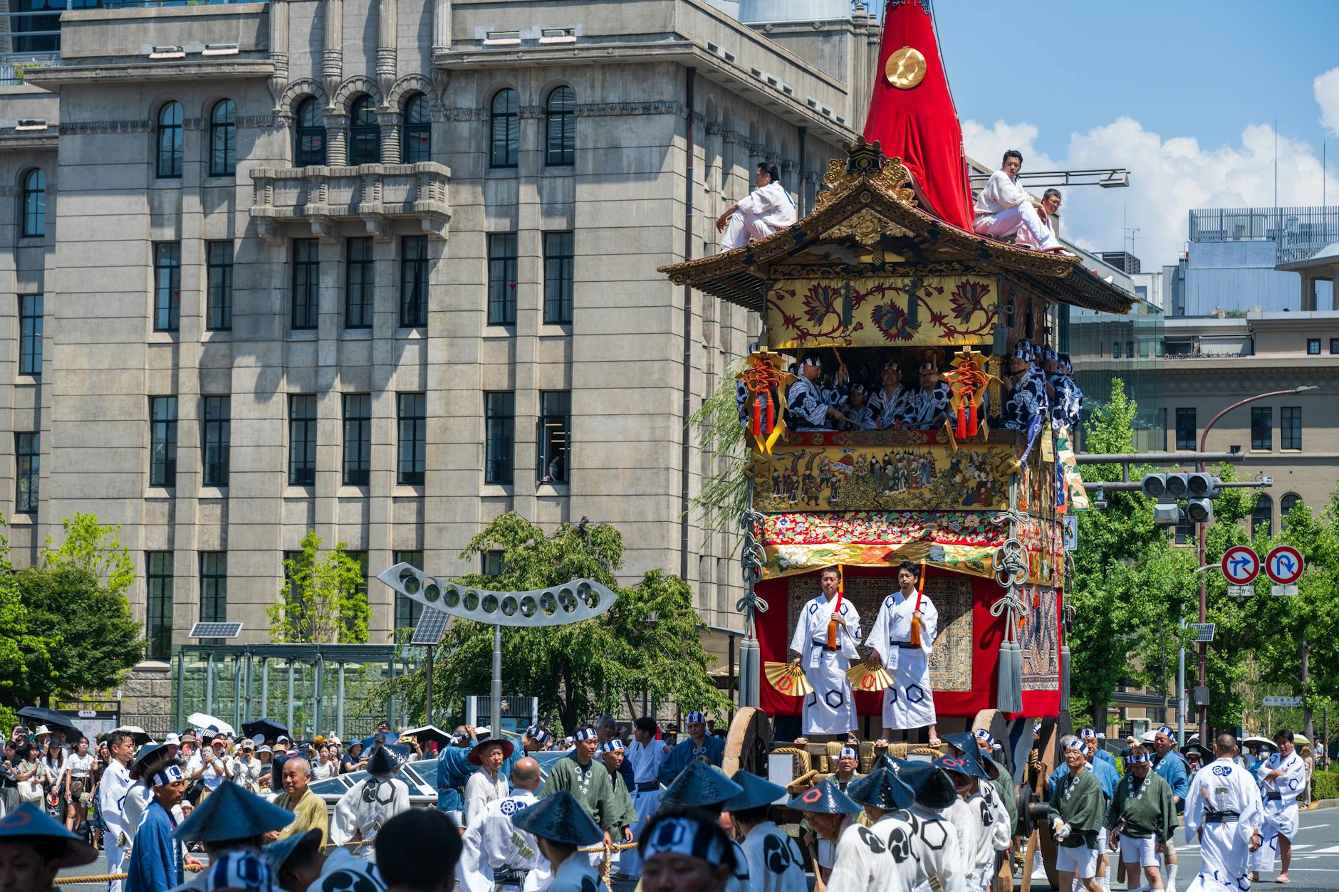 Colorful mikoshi portable shrine carried through crowded street during summer matsuri festival with paper lanterns overhead.