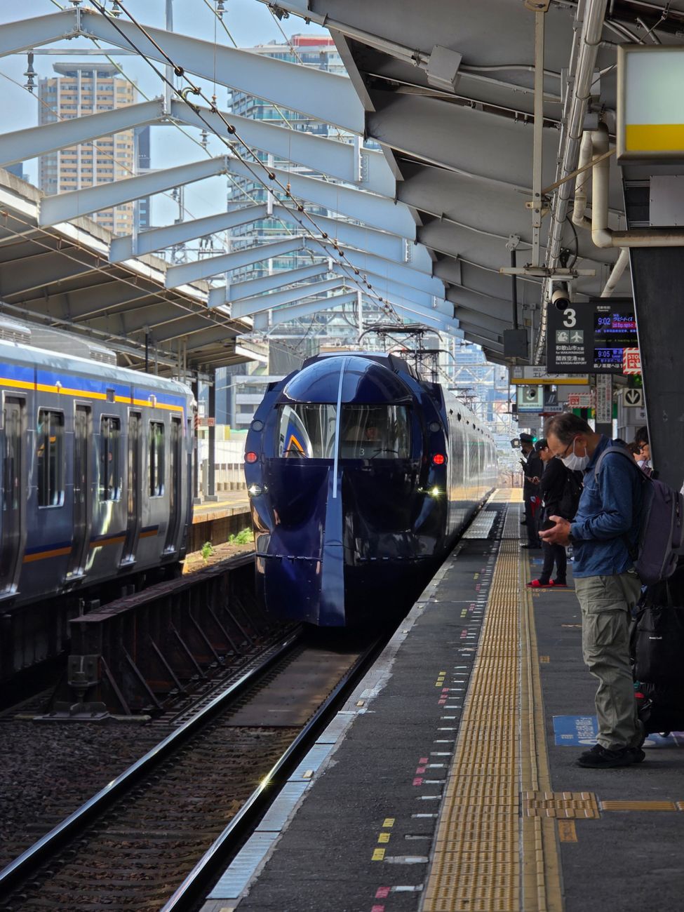Sleek white Shinkansen bullet train waiting at a spotless platform under a modern station canopy in Japan.