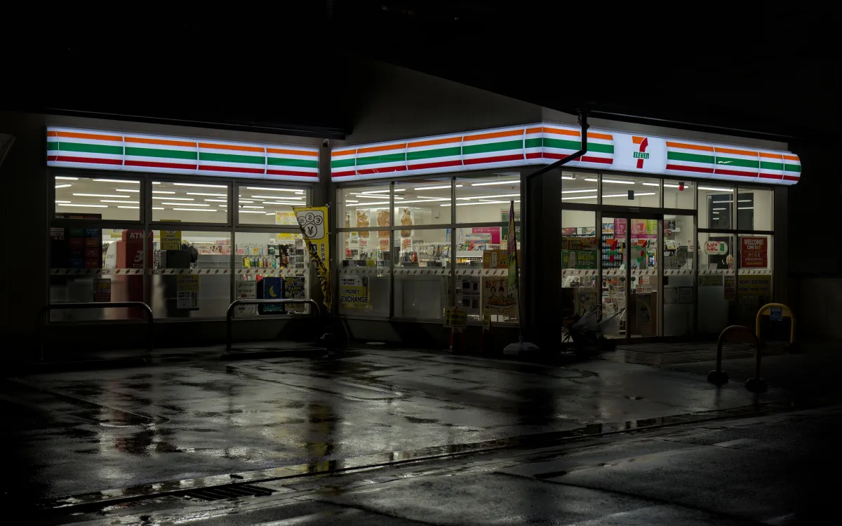 The bright interior of a Japanese convenience store at night, shelves neatly stocked with fresh food