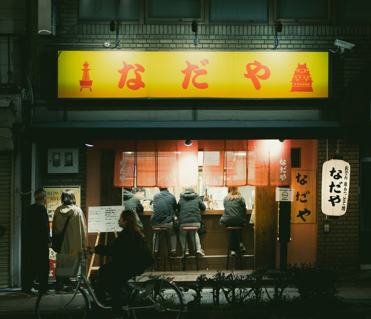 Colorful plastic food samples including ramen, sushi, and tempura arranged in a Japanese restaurant display window in Tokyo.