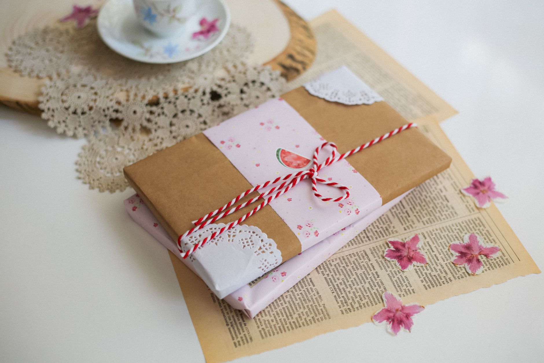 Silk furoshiki cloth wrapping a ceramic teapot using traditional Japanese folding technique with precise corners and elegant knot.