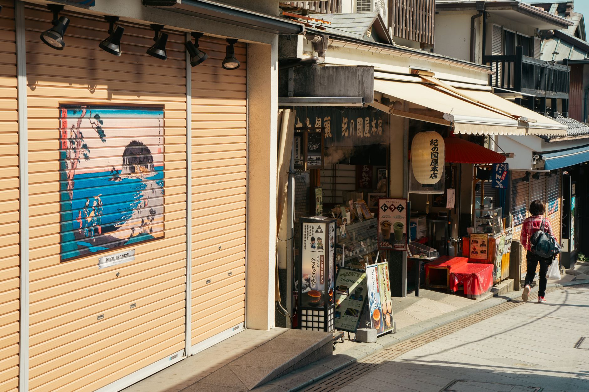 Colorful boxes of regional sweets and packaged treats displayed on shelves in a traditional Japanese omiyage gift shop.