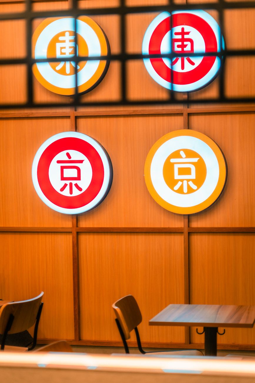 Traditional Japanese restaurant interior showing a wooden table with a small electronic call button device next to chopsticks and tea cups.