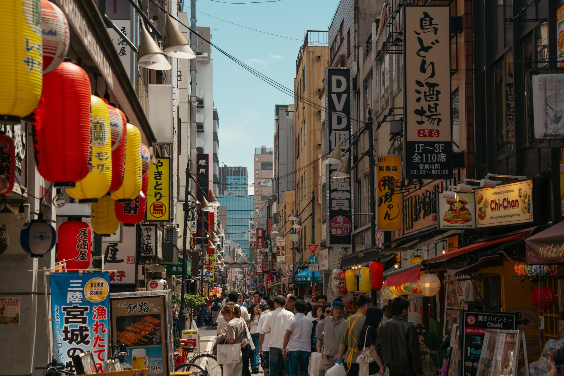 Two Japanese people bowing politely to each other on a city street in a gesture of apology or gratitude.