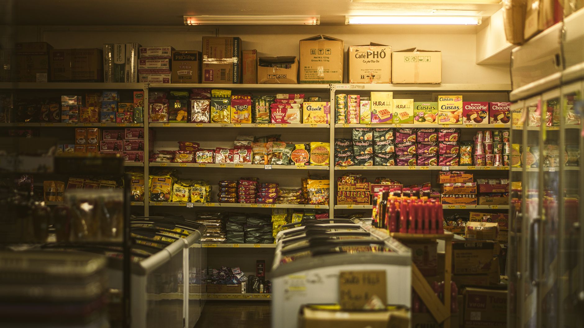 Colorful rows of limited edition seasonal snack packages displayed on Japanese convenience store shelves with sakura and autumn motifs.