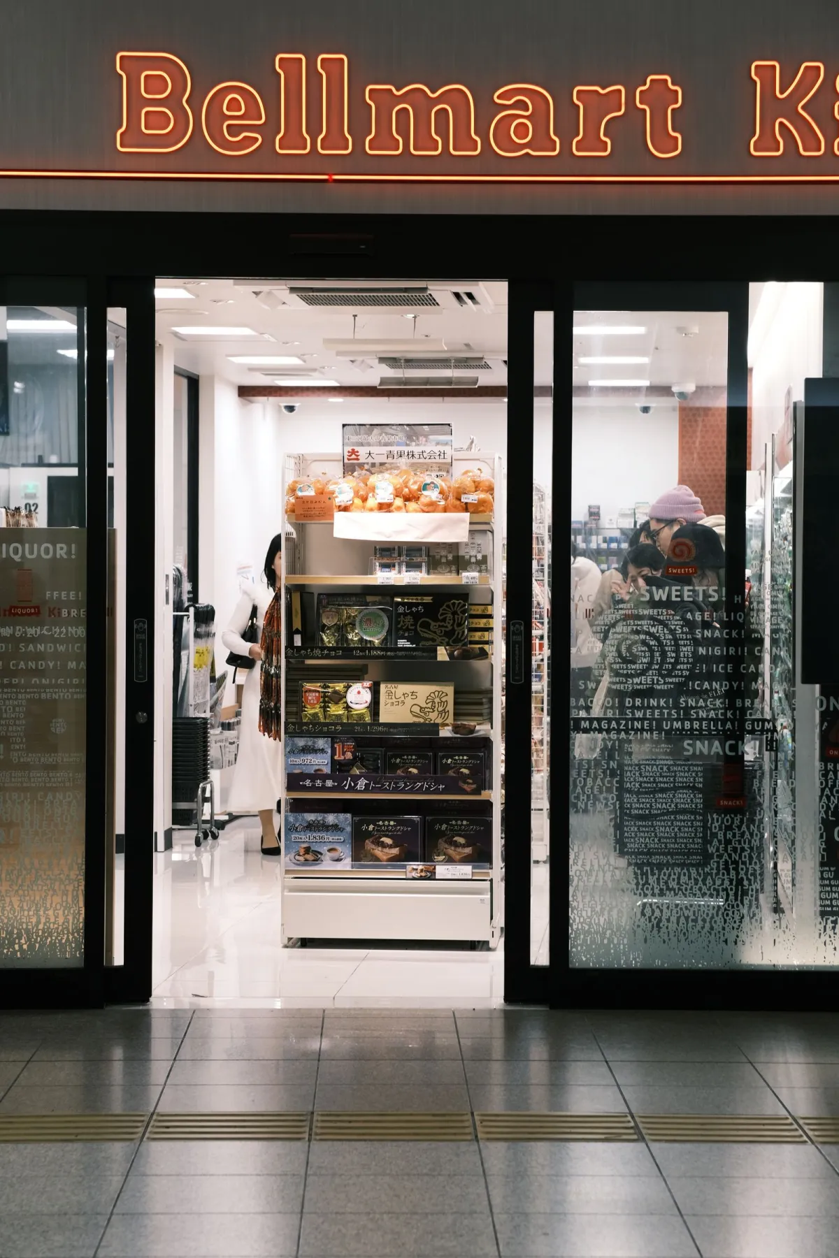 Colorful rows of limited edition seasonal snack packages displayed on Japanese convenience store shelves with sakura and autumn motifs.